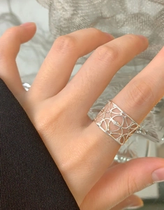 Dettaglio dell'anello a fascia larga traforata in argento S925 indossato sul medio di donna