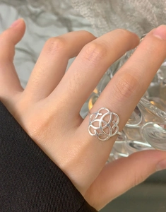 Close-up of S925 sterling silver ring with intricate hollowed heart patterns on finger
