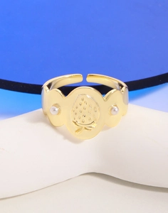 Détail d'une bague dorée avec gravure fraise et deux perles blanches sur les côtés