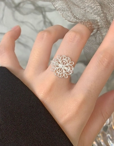 Close-up of S925 sterling silver ring featuring an elegant hollow flower petal design