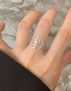 Detail of hollow heart ring on finger with elegant vintage floral patterns in silver
