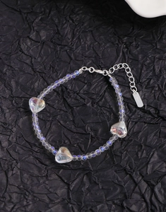 Macro detail of S925 sterling silver stamp on iridescent heart beaded bracelet