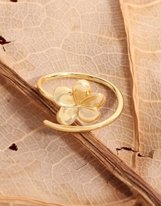 Close-up of golden flower ring on a natural brown leaf background with mirror finish