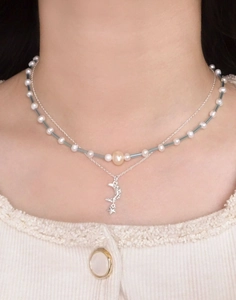 Détail d'un collier double rang avec perles naturelles, perles bleues et pendentif lune étoile