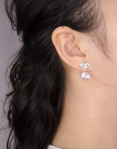 Gros plan de boucles d'oreilles papillon en argent S925 avec zircons sur l'oreille