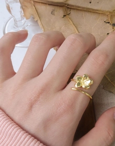 Detail of adjustable gold floral ring featuring polished five-petal flower on hand