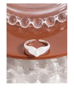 Macro shot of S925 sterling silver heart ring with pearl on ceramic plate