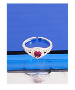 Detail view of heart-shaped red stone and S925 silver engraving on open ring