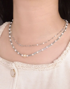 Gros plan du collier double rang en argent S925 avec perles blanches et perles bleues