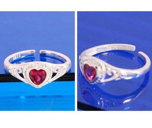 Macro detail of S925 sterling silver heart ring with red corundum and filigree