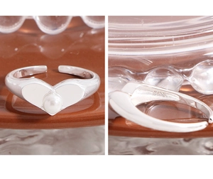 Macro shot of S925 sterling silver stamp and lustrous heart pearl on the open ring