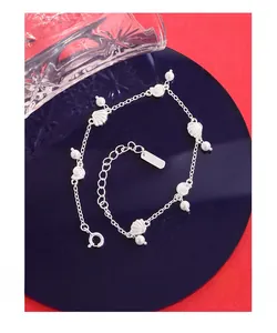 Détail d'un bracelet en argent S925 avec pendentif coquillage et perles blanches polies
