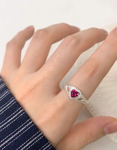 Macro detail of S925 silver ring featuring heart-cut red corundum and hollow patterns