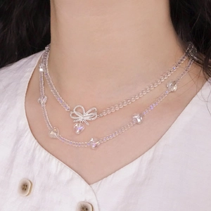 Double-layer beaded necklace with silver bow and transparent heart pendant on model