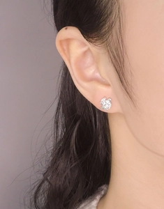 Close-up of S925 silver flower stud earring with marquise cubic zirconia on ear
