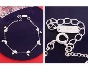 Gros plan du poinçon S925 et du pendentif coquillage sur un bracelet en perles fines