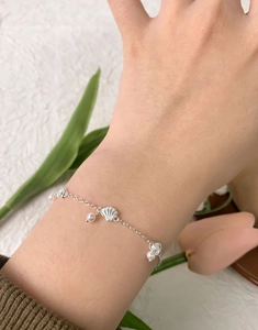 Détail du bracelet en argent S925 avec pendentif coquillage et perles au poignet