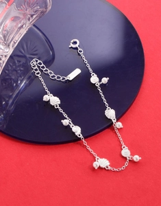 Gros plan sur bracelet en argent S925 avec des coquillages et des perles blanches