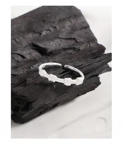 Macro shot of S925 sterling silver twisted ring with bamboo texture on black coal