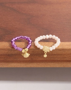 Détail de bagues en perles d'argent S925 avec breloques chat et théière en violet et rose