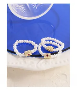 Detail of freshwater pearl ring with hammered gold buckle and red gemstone inlay