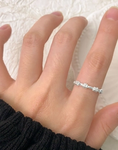 Close-up of minimalist S925 sterling silver spiral beaded ring worn on female finger