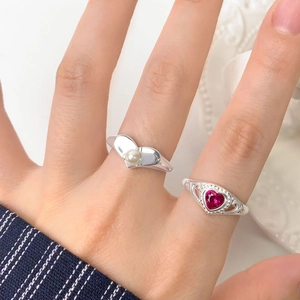 Elegant S925 silver rings with heart ruby and white pearl on a ceramic tray