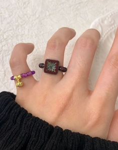 Détail de bagues en perles d'argent S925 avec une clochette dorée et des breloques rétro