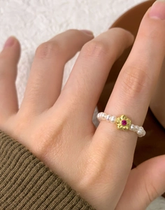 Détail d'une bague en argent S925 avec perles d'eau douce et fleur en or à zircon rouge
