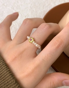Vue détaillée d'une bague en argent S925 avec perles d'eau douce et fleur dorée