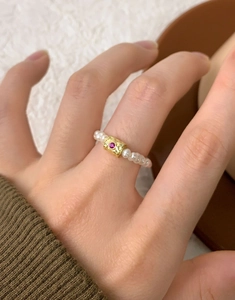 Detail of S925 silver ring with freshwater pearls and a golden cylinder with pink gem