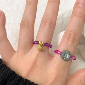 Bagues en perles colorées faites main avec breloques théière et fleur sur mannequin