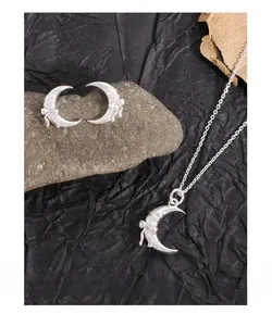 Detailed close-up of S925 silver crescent moon necklace and earrings with ribbon bows