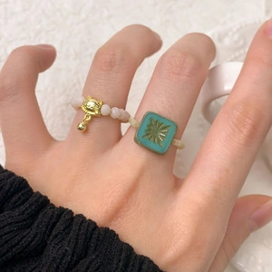 Bague élastique en perles roses avec grelot chat et bague étoile vintage sur la main