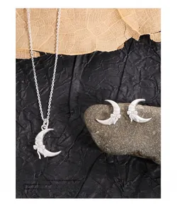 Detailed macro view of S925 sterling silver crescent moon earrings with bow design