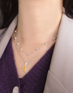 Detail of S925 sterling silver layered necklace with orange enamel pendant on model