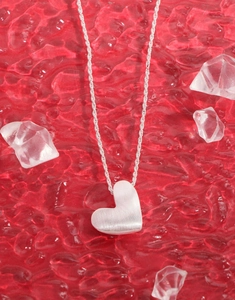 Close-up of brushed S925 sterling silver heart pendant on an elegant twist chain