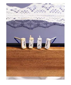 Detail of rectangular zircon stud earrings in S925 silver and 18K gold plated finish