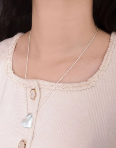 Detail of S925 sterling silver heart necklace featuring a brushed matte texture finish
