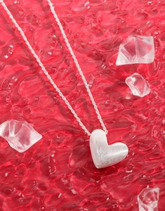 Detailed close-up of S925 sterling silver heart necklace with brushed matte finish texture