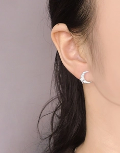 Close-up of S925 sterling silver bow moon earrings with sparkling zircons worn on ear
