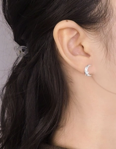 Macro view of S925 sterling silver moon stud earring on ear with intricate relief detail