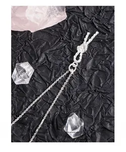 Detail view of S925 sterling silver knotted rope pendant necklace on black background