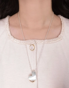 Close-up of minimalist S925 sterling silver heart pendant necklace on model