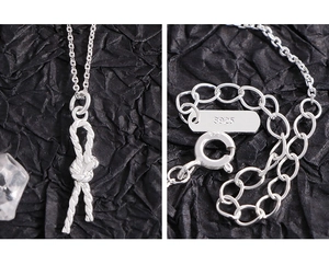 Detailed view of S925 sterling silver stamp and knot pendant on a twisted chain necklace