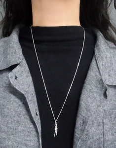 Long S925 sterling silver twist knot pendant necklace on model with grey cardigan