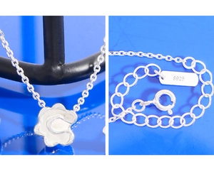 Dettaglio macro della collana in argento S925 con ciondolo a fiore, chiusura e incisione