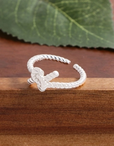 Detailed close-up of S925 sterling silver twisted knot ring on dark wooden surface