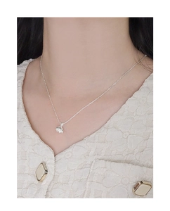 Dettaglio della collana minimalista in argento S925 con fiore indossata da modella