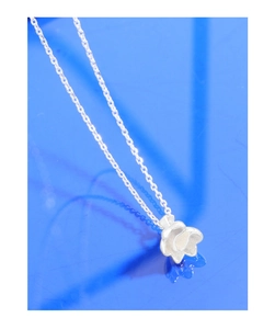 Vista macro dettagliata del ciondolo a fiore in argento sterling S925 con bordi lucidi su blu